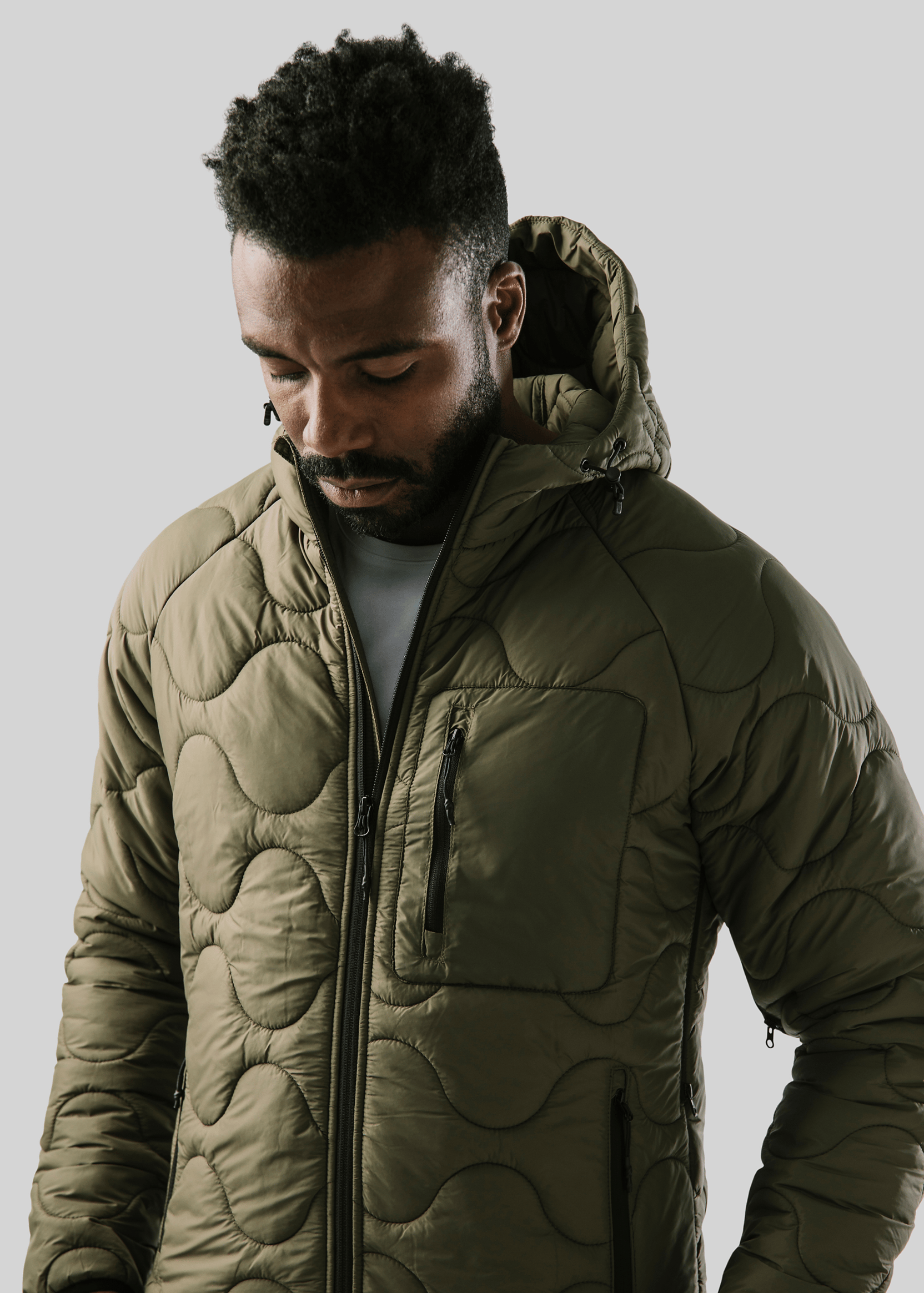 Nahaufnahme eines Mannes in einer wattierten Jacke – anklickbarer Link zu unseren Marken.