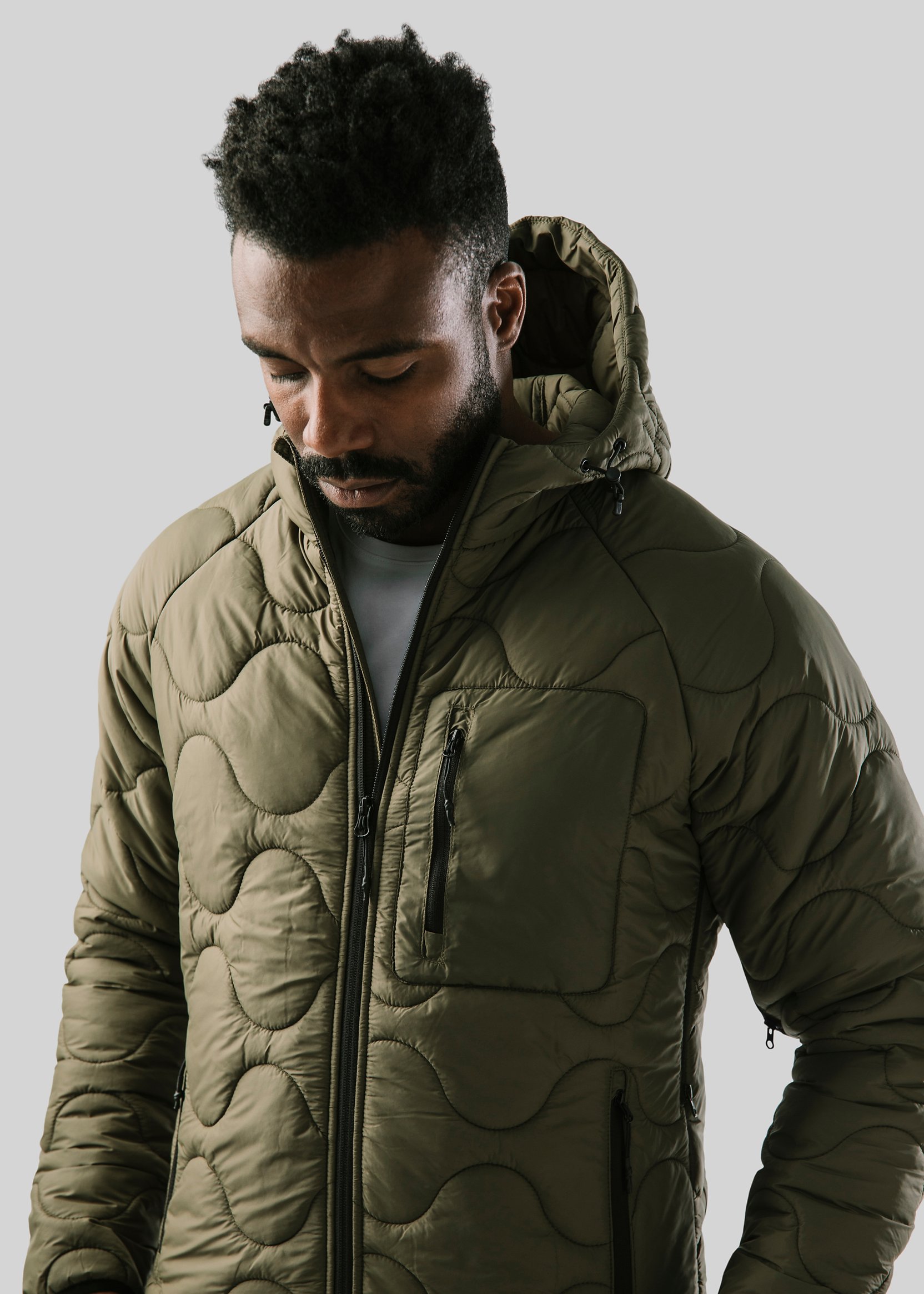 Nahaufnahme eines Mannes in einer wattierten Jacke – anklickbarer Link zu unseren Marken.