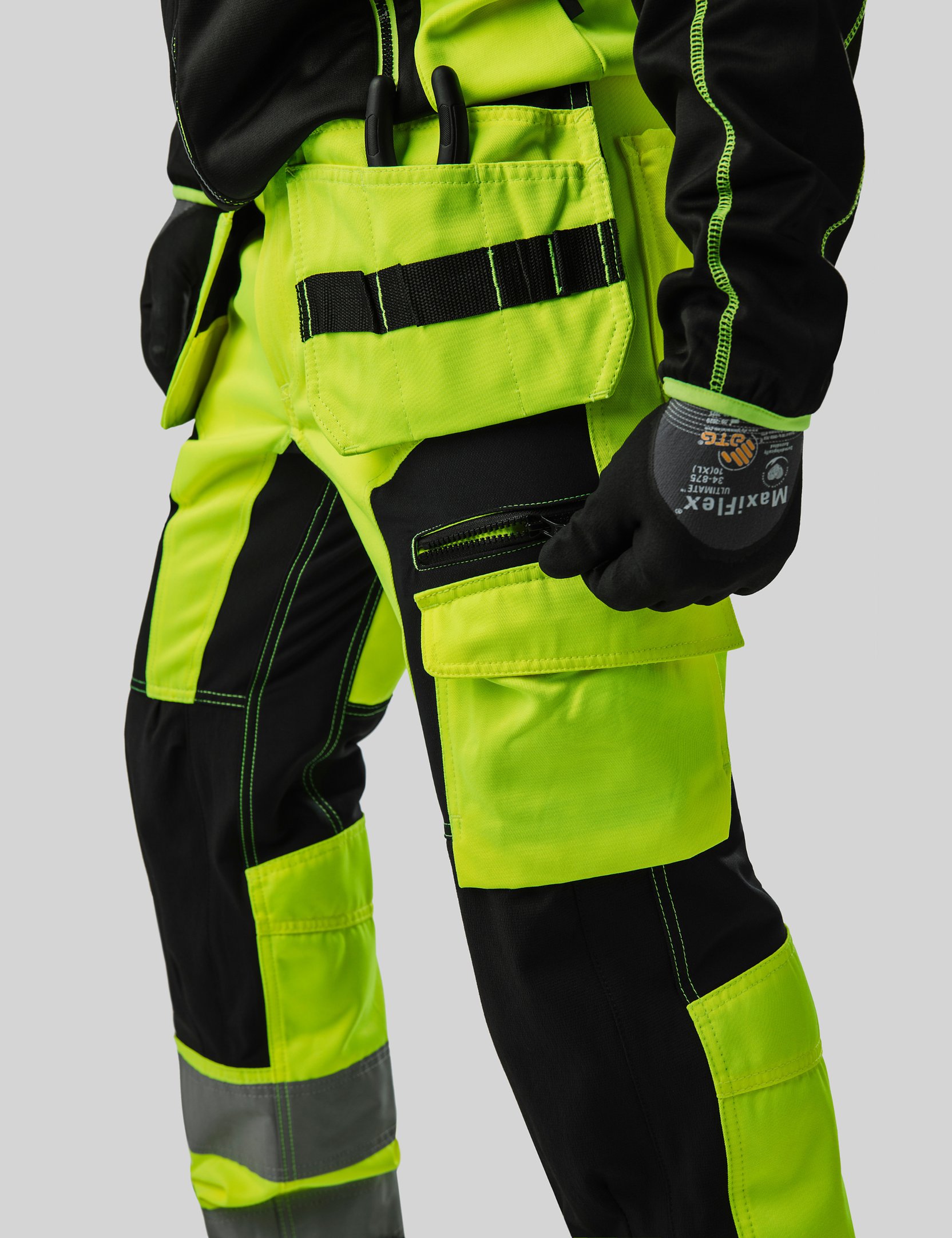 Nahaufnahme einer neongrünen und schwarzen Arbeitshose von Top Swede; Klicken Sie hier, um die Größentabelle anzuzeigen.