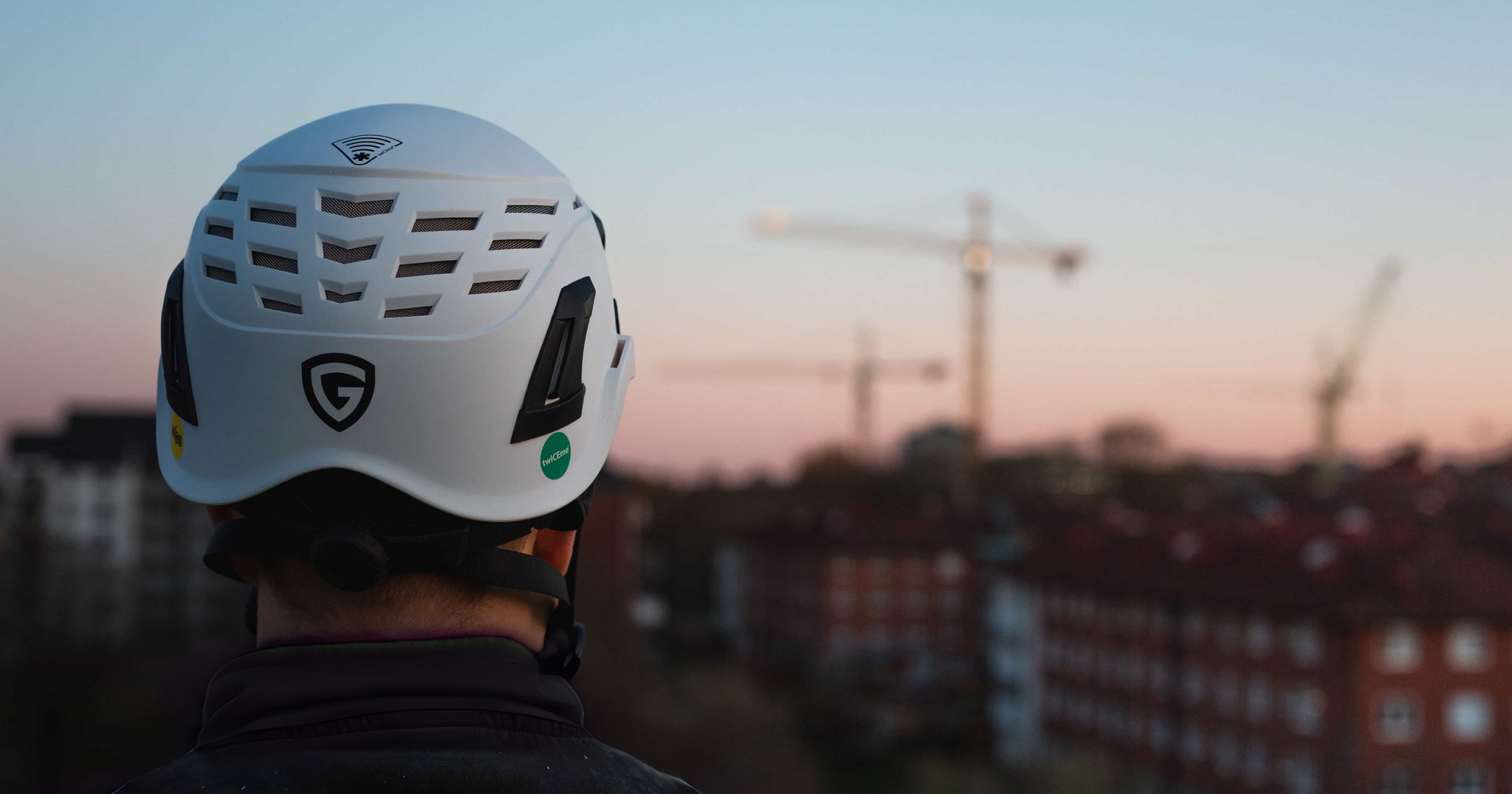 Person med en Guardio-sikkerhedshjelm set bagfra, udstyret med Twiceme-logoet og NFC-symbolet på toppen af hjelmen, der angiver, hvor den digitale Twiceme-sensor er placeret.