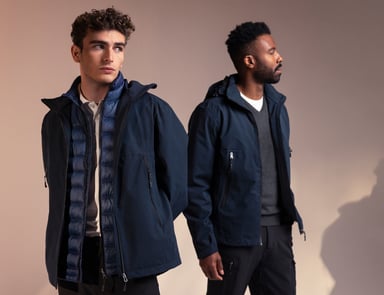Zwei Männer in passender Oberbekleidung aus dem South West – dunkelblaue Jacken mit wärmenden Schichten darunter, perfekt für wechselndes Wetter. Anklickbarer Link zu Produkten aus dem South West.