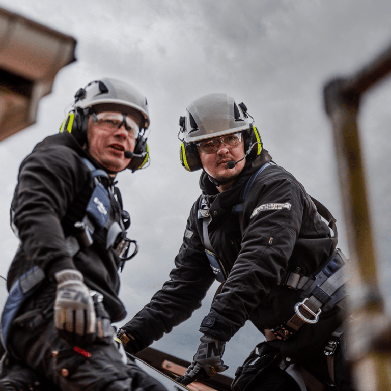 Two workers up on a roof wearing 3M safety helmets