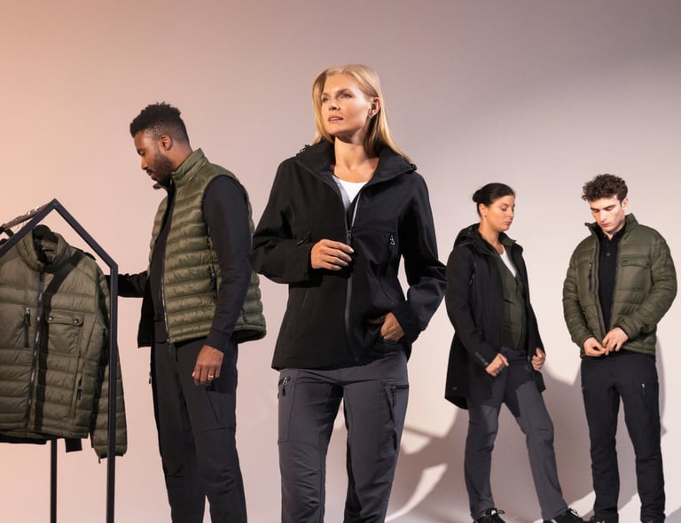 Grupp med modeller visar upp South Wests kollektion med funktionsjackor och västar – plagg för både arbete och vardag. Klickbar länk till South West The Mix Concept-sidan.
