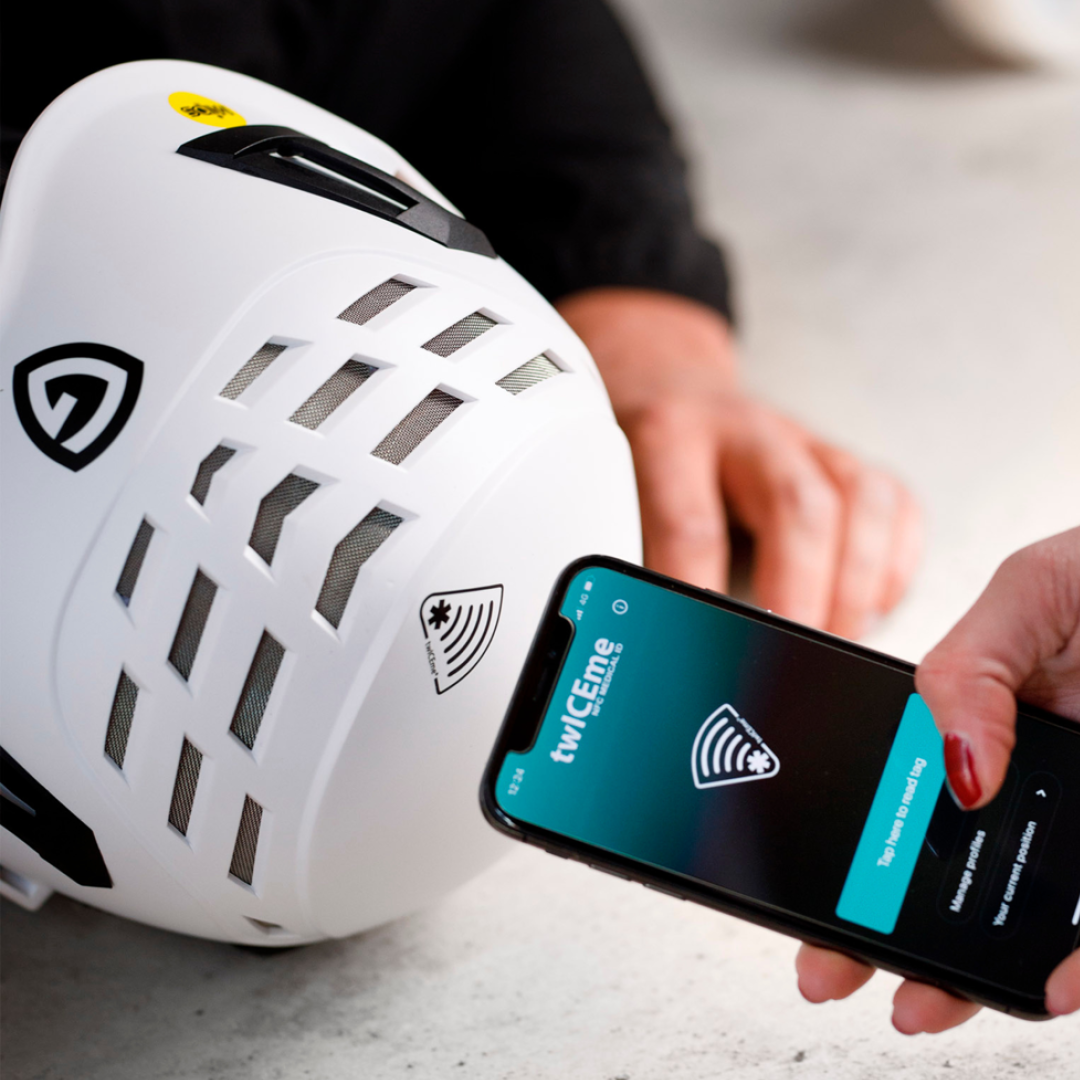 En hånd, der holder en telefon med TwICEme-appen og scanner en Guardio-sikkerhedshjelm