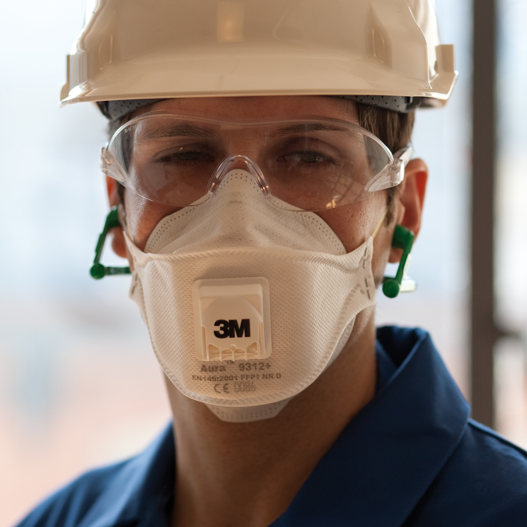 Bild på en arbetare iklädd skyddshjälm, glasögon och andningsskydd från 3M