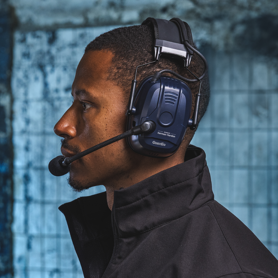 A model in an industrial environment, wearing Guardio Freebird hearing protection