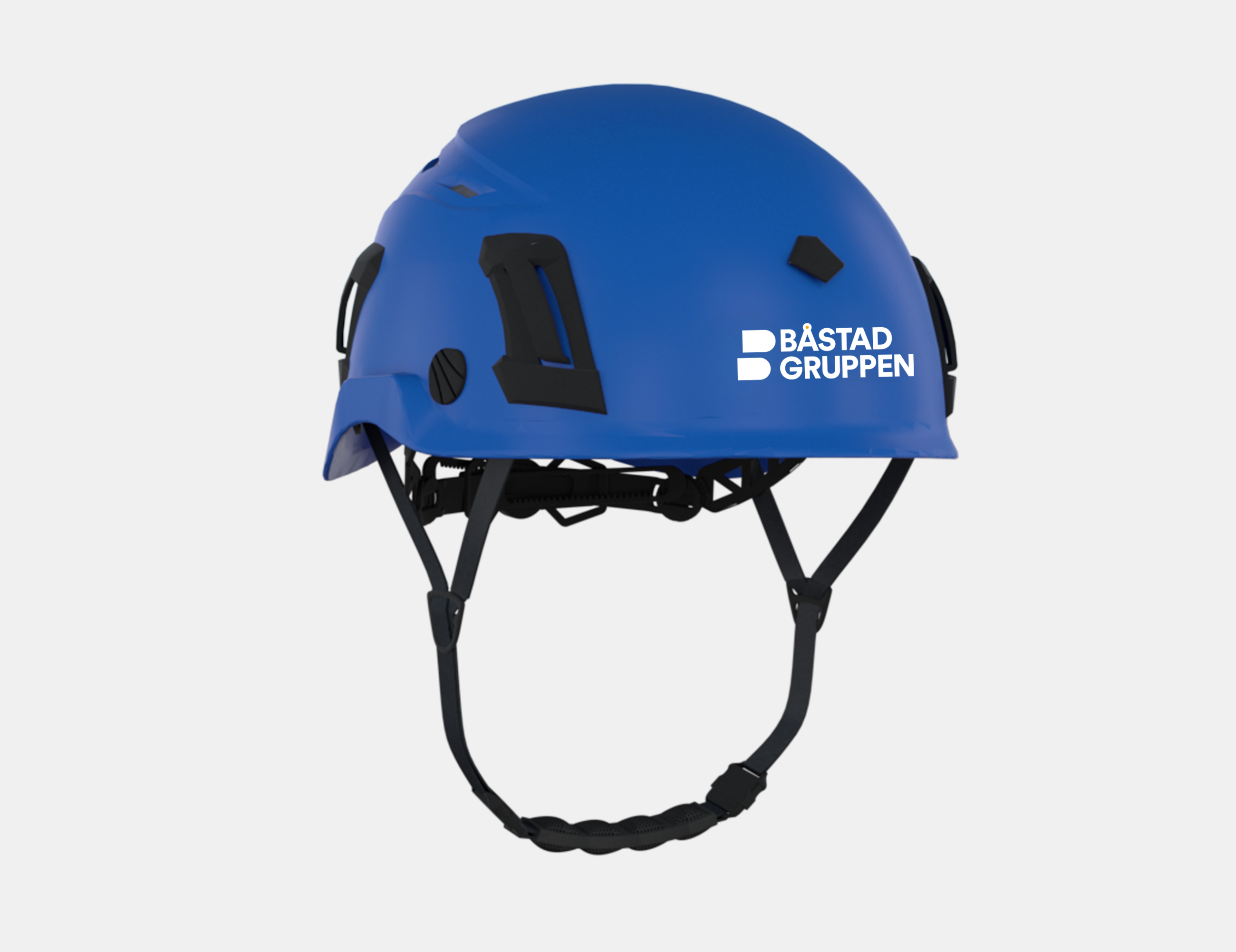 Blå sikkerhedshjelm med Båstadgruppen-logo og påsat klistermærke.