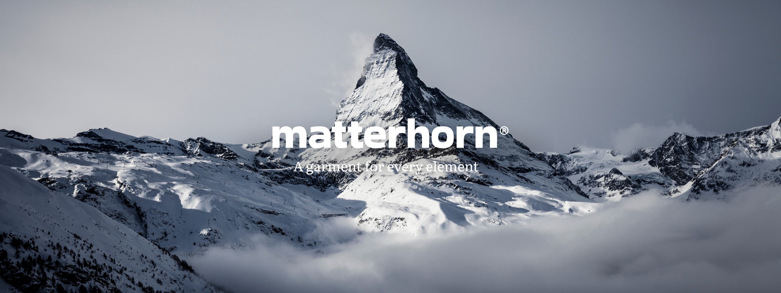 Snedækkede Matterhorn med logoet “matterhorn – A garment for every element” i hvidt foran bjergtoppen. Klikbart billede med link til Matterhorn-produkterne i webshoppen.